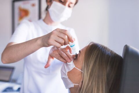 A nurse applying eye drops to a woman wearing a mask in East Stroudsburg, PA